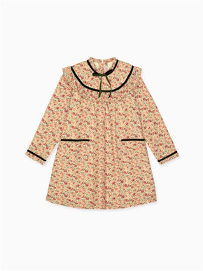 Floral patterned children’s dress in cream with red flowers and black trim, featuring a ruffled collar and front pockets.