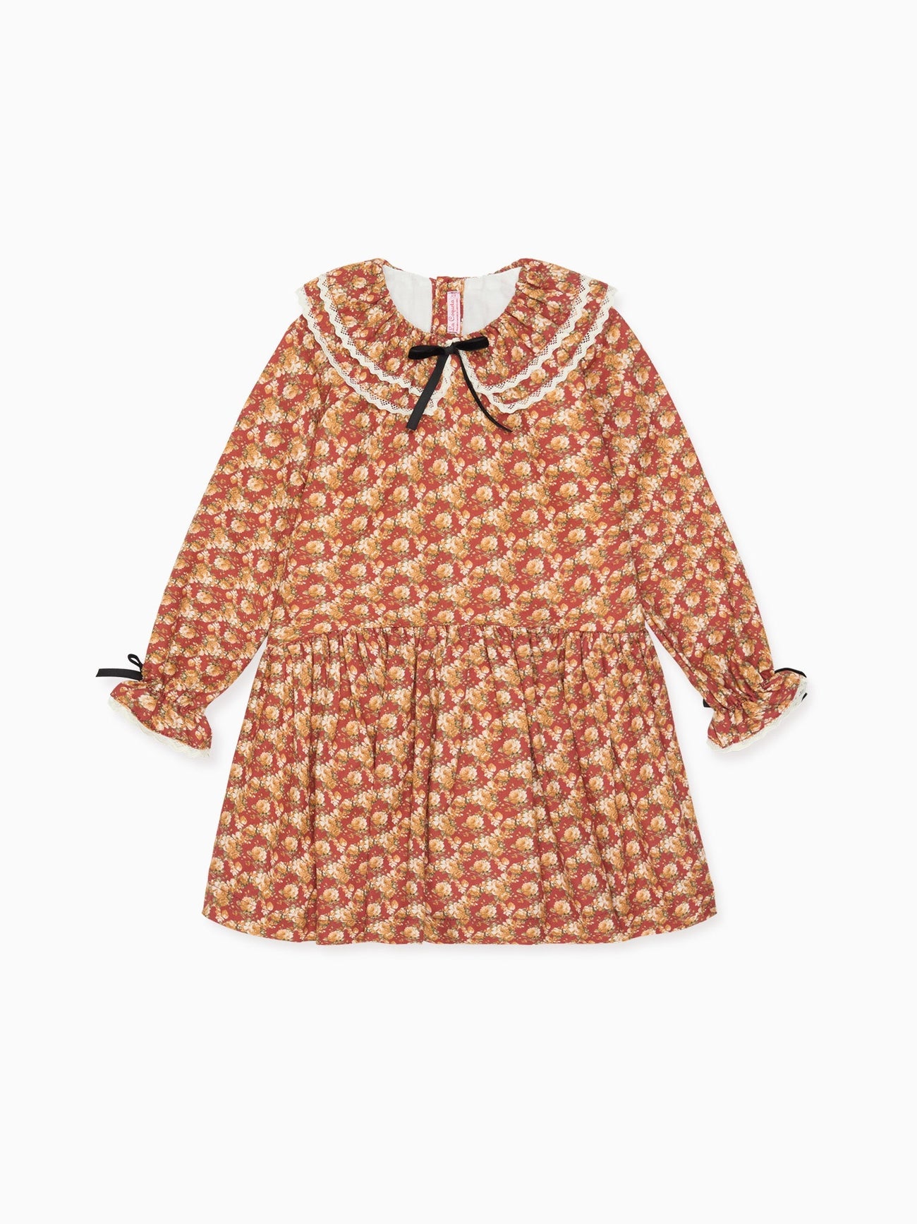 Long-sleeved floral children's dress with a lace-trimmed collar and black bows, featuring warm red and yellow tones.